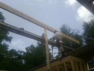 Carpenter setting a ridge beam over a new addition frame — Ice Dam Removal by Roofing Brothers in Driggs