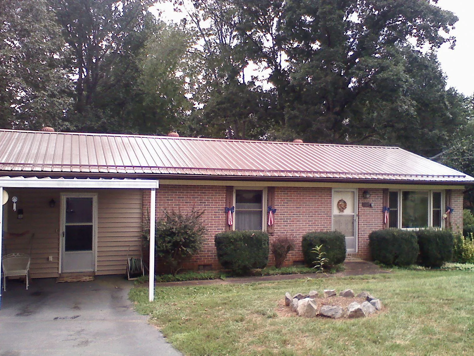 Bronze metal roof and carport on a brick ranch home — Roof Repair work by our crew in Driggs